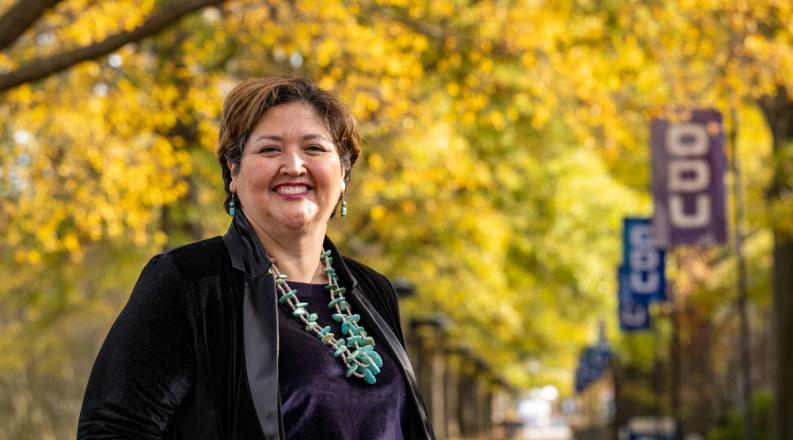 portrait of a woman with fall leaves and old dominion university flags in the background