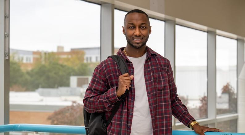 photo of a student wearing a red flannel shirt with is backback