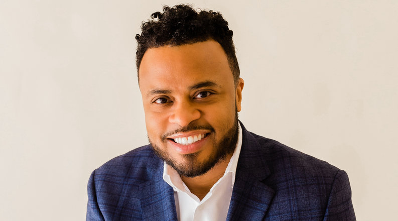 A man sits against a white background. 