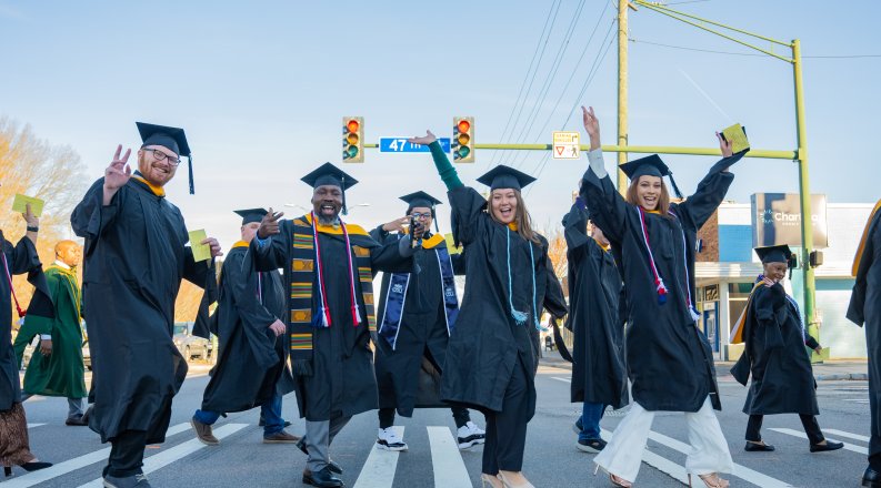 A group of students cross the street.