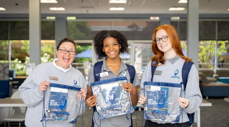 Three people holding bags