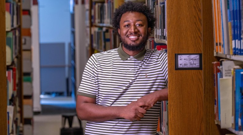 Jerome Newsome stands by library shelf