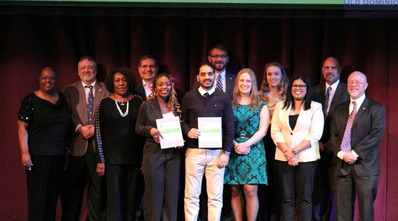 A group of people stand on a stage.