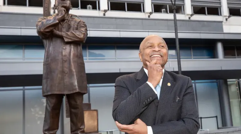 Dr. L.D. Britt stands in front of his statue on the EVMS cam