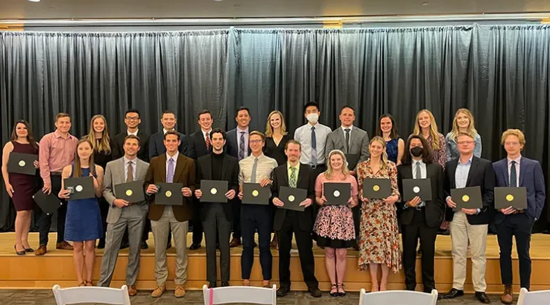 students standing in two lines in front of stage