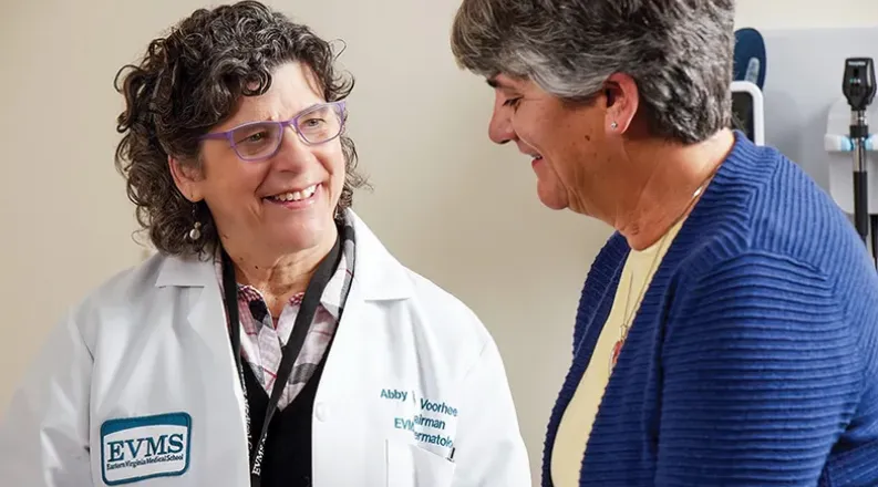 Dr. Abby Van Voorhees has medium curly hair, is wearing glas