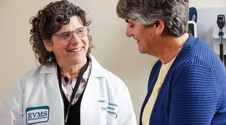 Dr. Abby Van Voorhees has medium curly hair, is wearing glas
