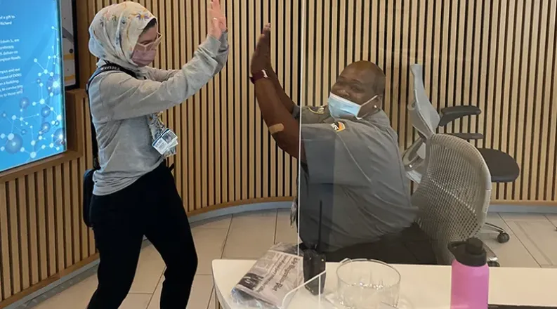 student air-fiving with security guard