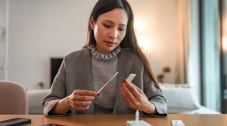 A business woman dressed in a sweater and blazer sits at a t
