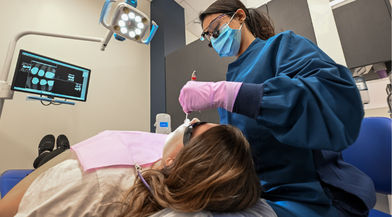 Female dental technician works on patient