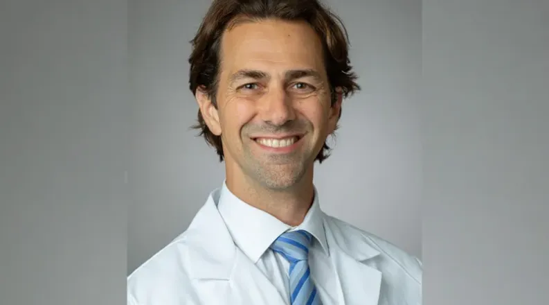 Dr. DiSandro has short brown hair and is wearing a white shi