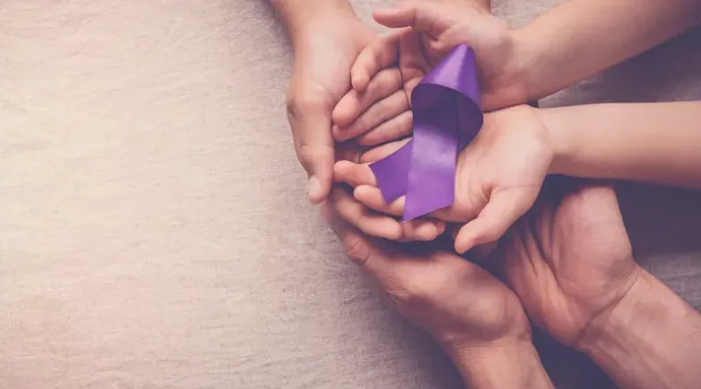 Hands holding a purple ribbon