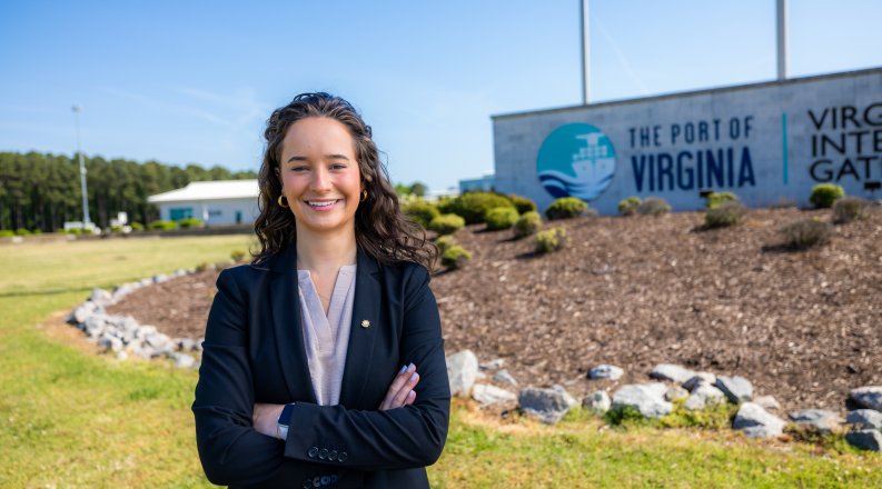 Finley Stoops stands in front of Port of Virginia sign. 