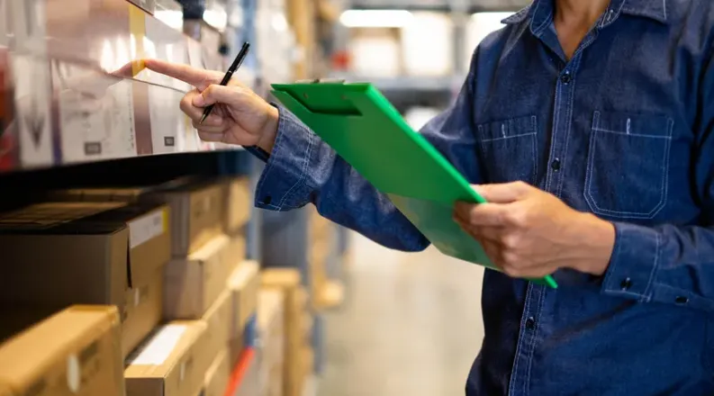 Worker in a warehouse with clipboard