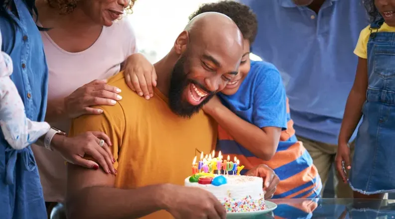 Black Man blowing out birthday candles
