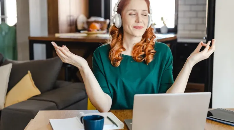 Woman meditating in front of a laptop