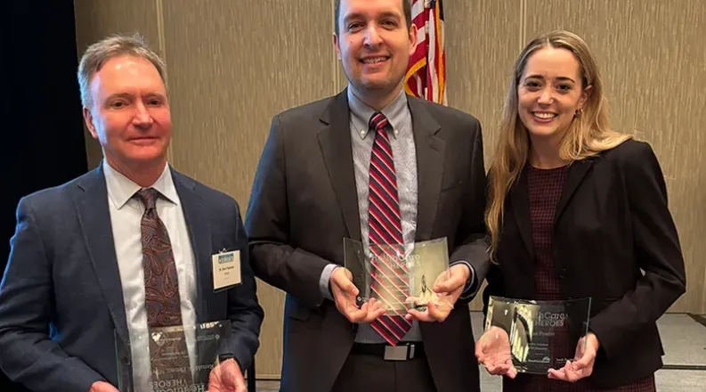 three people with trophies.