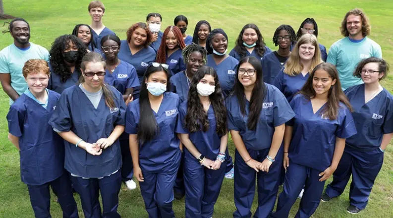 students gathered on lawn in scrubs for HSA.