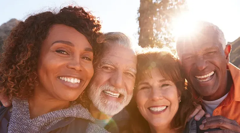 A diverse group of four seniors are being active outdoors. T