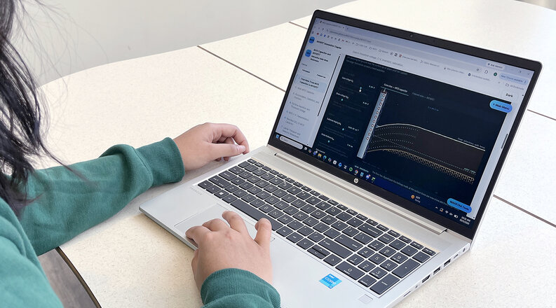 Hands typing on a laptop