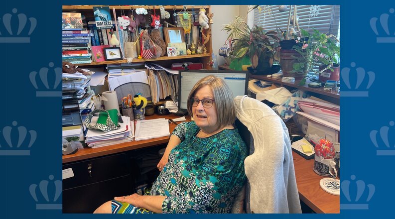 Fran Hassencahl, Ph.D., is shown seated in her Batten Arts and Letters Building office, surrounded by scholarly books, thriving plants and colorful toys.