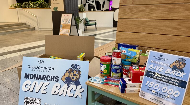 Monarchs Give Back sign with grocery items on bench