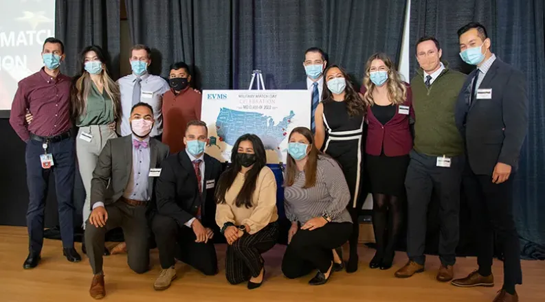 students posing on a stage next to a U.S. map