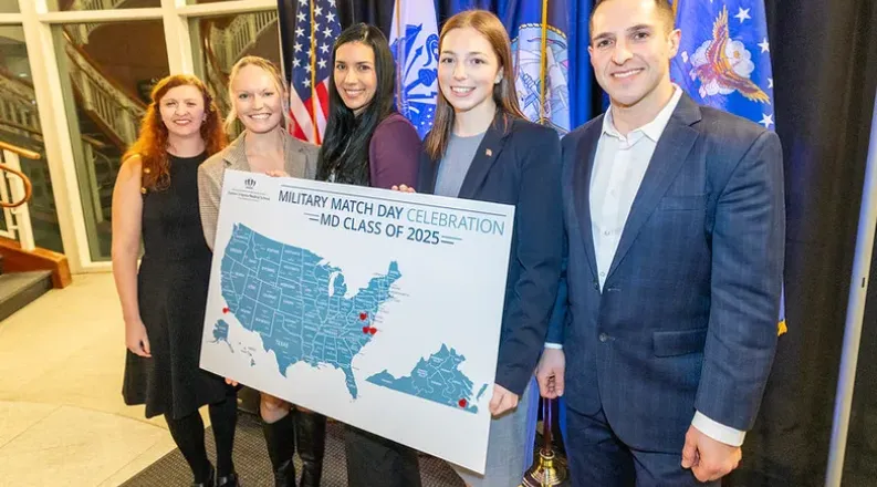 five people standing behind a map posing for a pic.