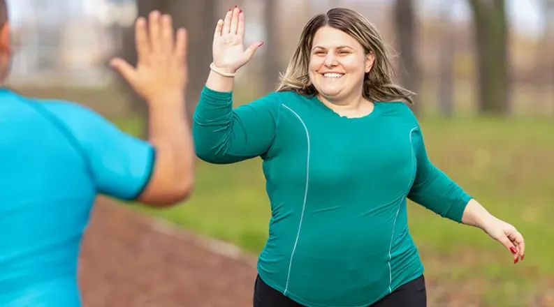 A happy overweight woman in teal blue sportswear top high-fi