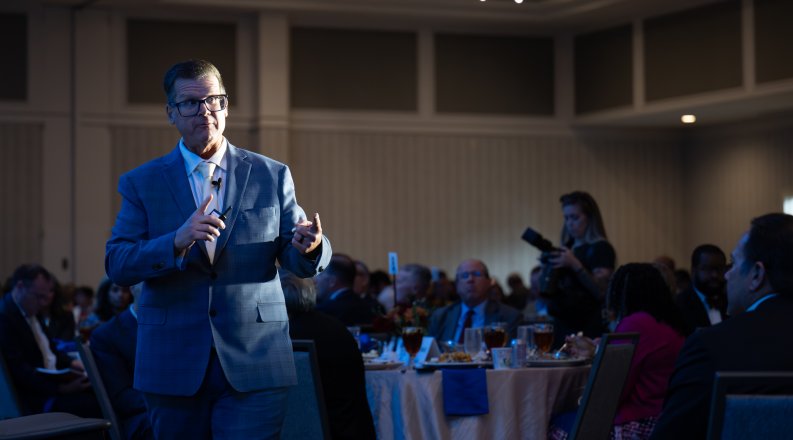 Bob McNab speaks to a crowded room.