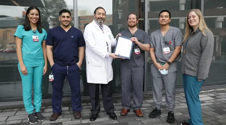 residents with Dr. Abuhamad presenting a document