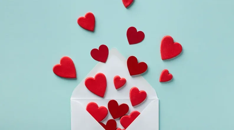an open envelope sits on a teal blue background with red hea