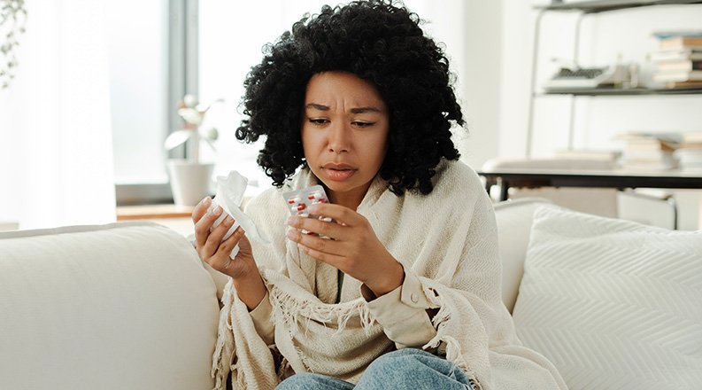 Sick woman reading medication label.