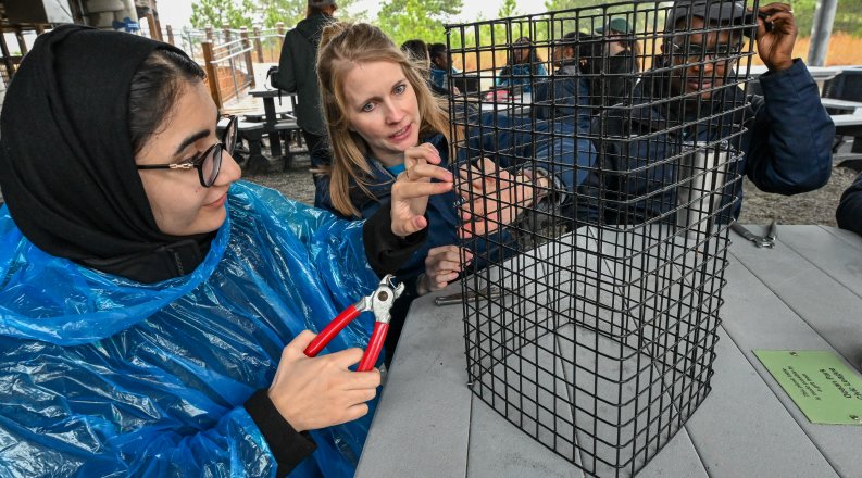 Two women work on oyster cage