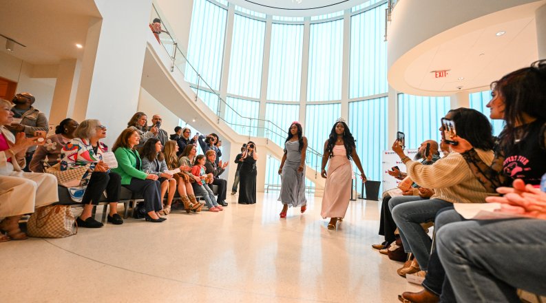 A group of people putting on a fashion show at the Barry Art Museum.
