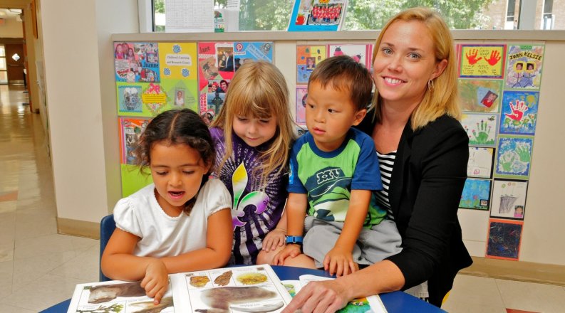A photo of a teacher with a group of kids.