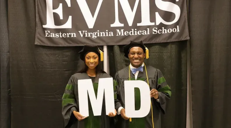 Two African American EVMS students hold the letters M and D