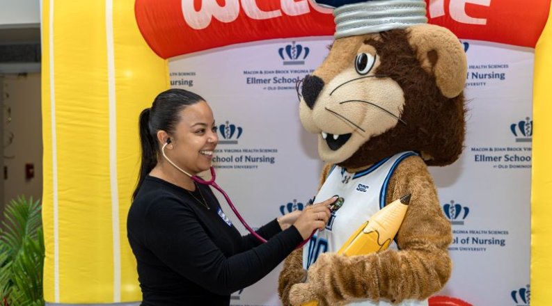 A woman uses a stethoscope to check the heartbeat of the ODU mascot