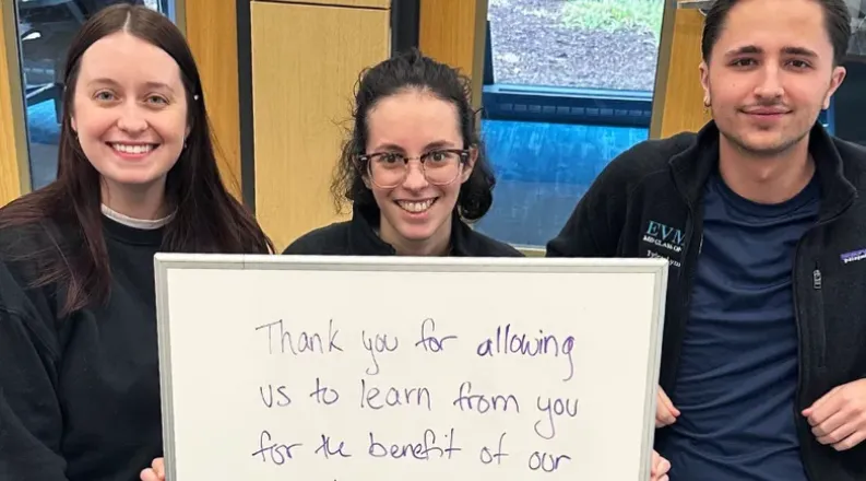 Three students with a dry erase board expressing gratitude f