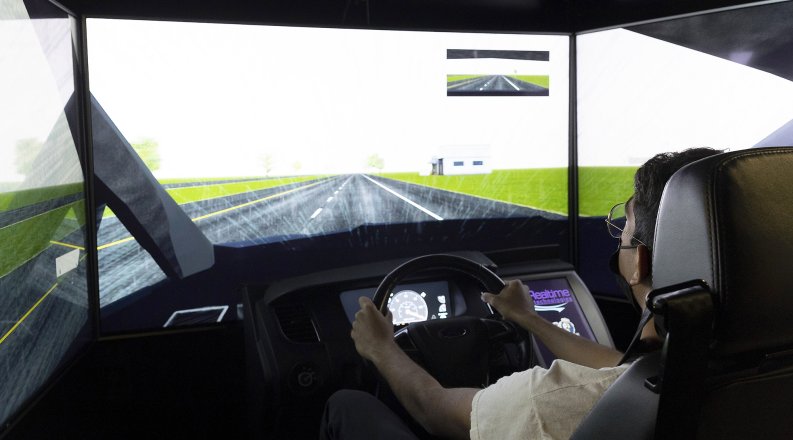 A student tests out a driving simulator. 
