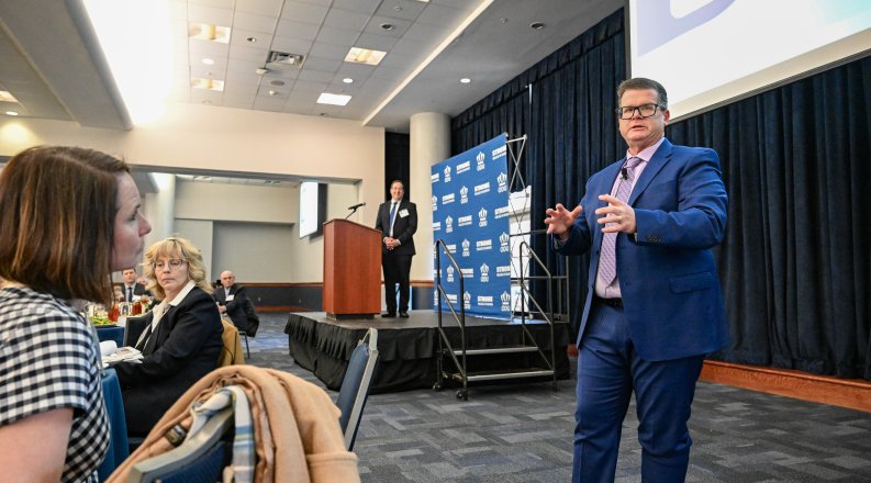 A man talks to a crowd of people.