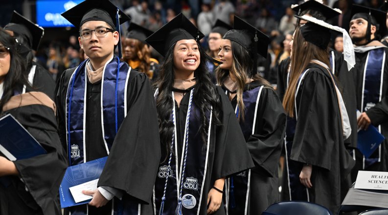 A group of graduates stand together at commencement