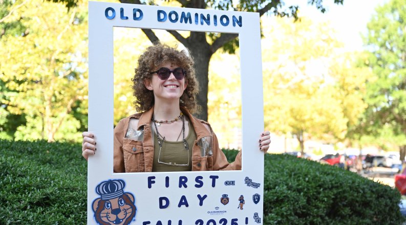 Person holding photo frame that reads "Old Dominion First Day of School Fall 2025"