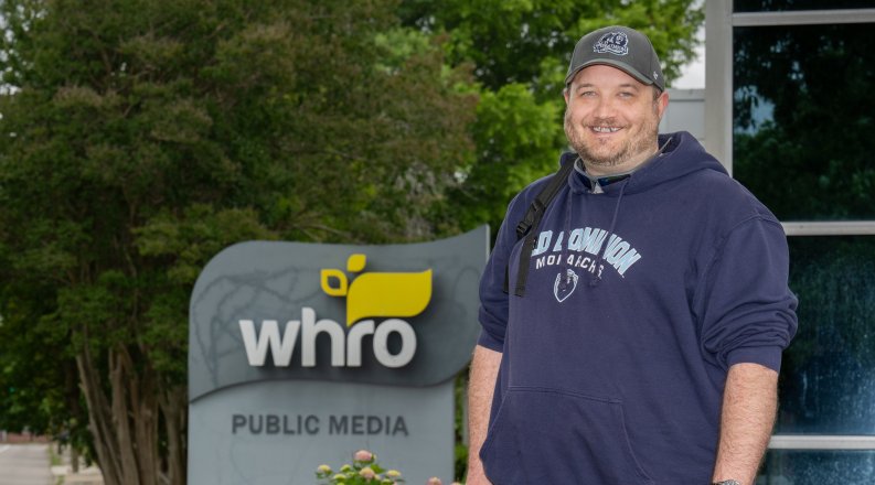Old Dominion University student George Degaraff stands in front of the WHRO sign