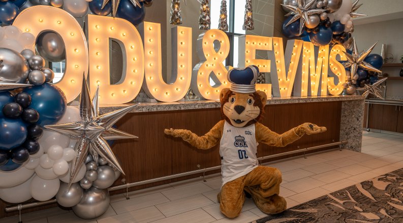 ODU's mascot poses in front of an ODU/EVMS sign. 