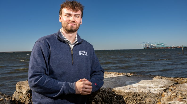 Joshua Seaford stands in front of water