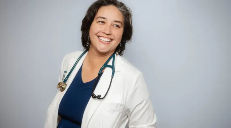 Woman smiling in white medical coat
