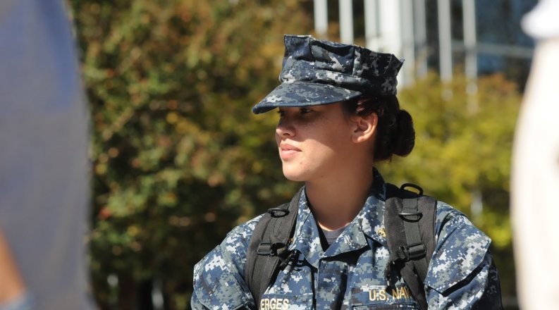 Woman in U.S. Navy fatigue with a bookbag on
