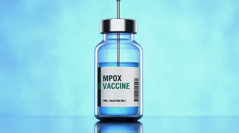 A needle punctures the top of a vial of mpox vaccine against