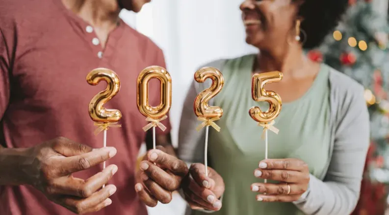 Two individuals smiling at each other in front of a Christma